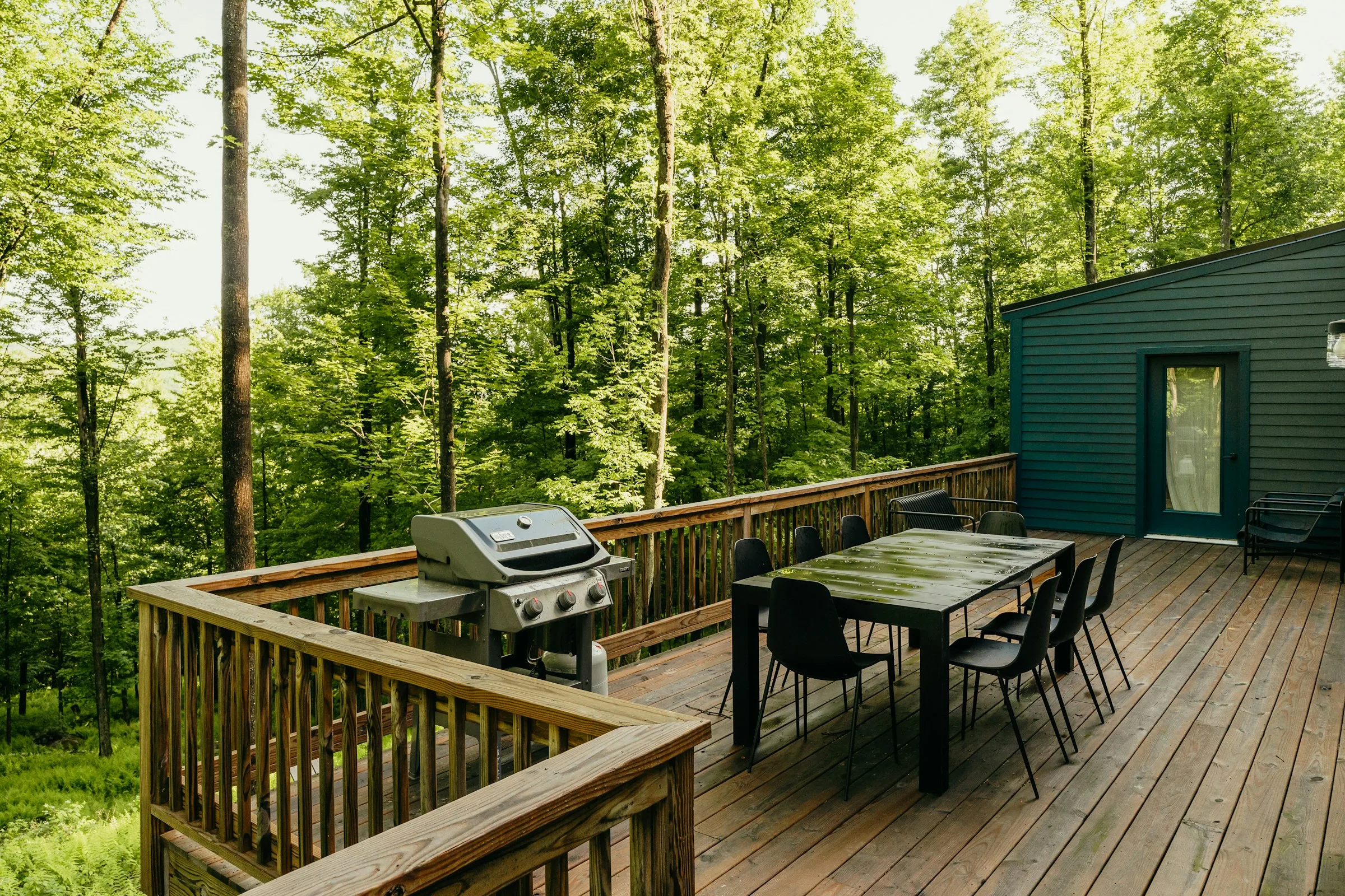 Elevated backyard deck with outdoor dining among trees