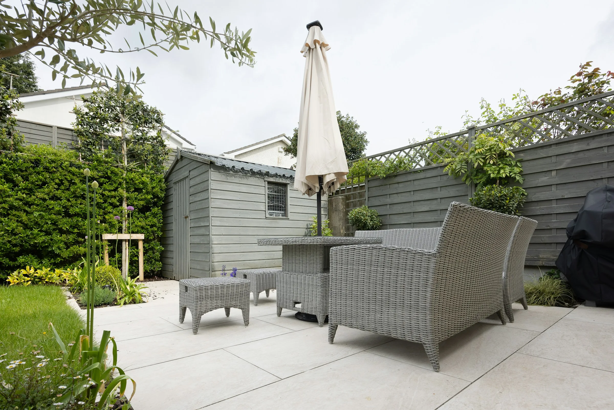 Landscaped backyard with a green lawn and paved patio