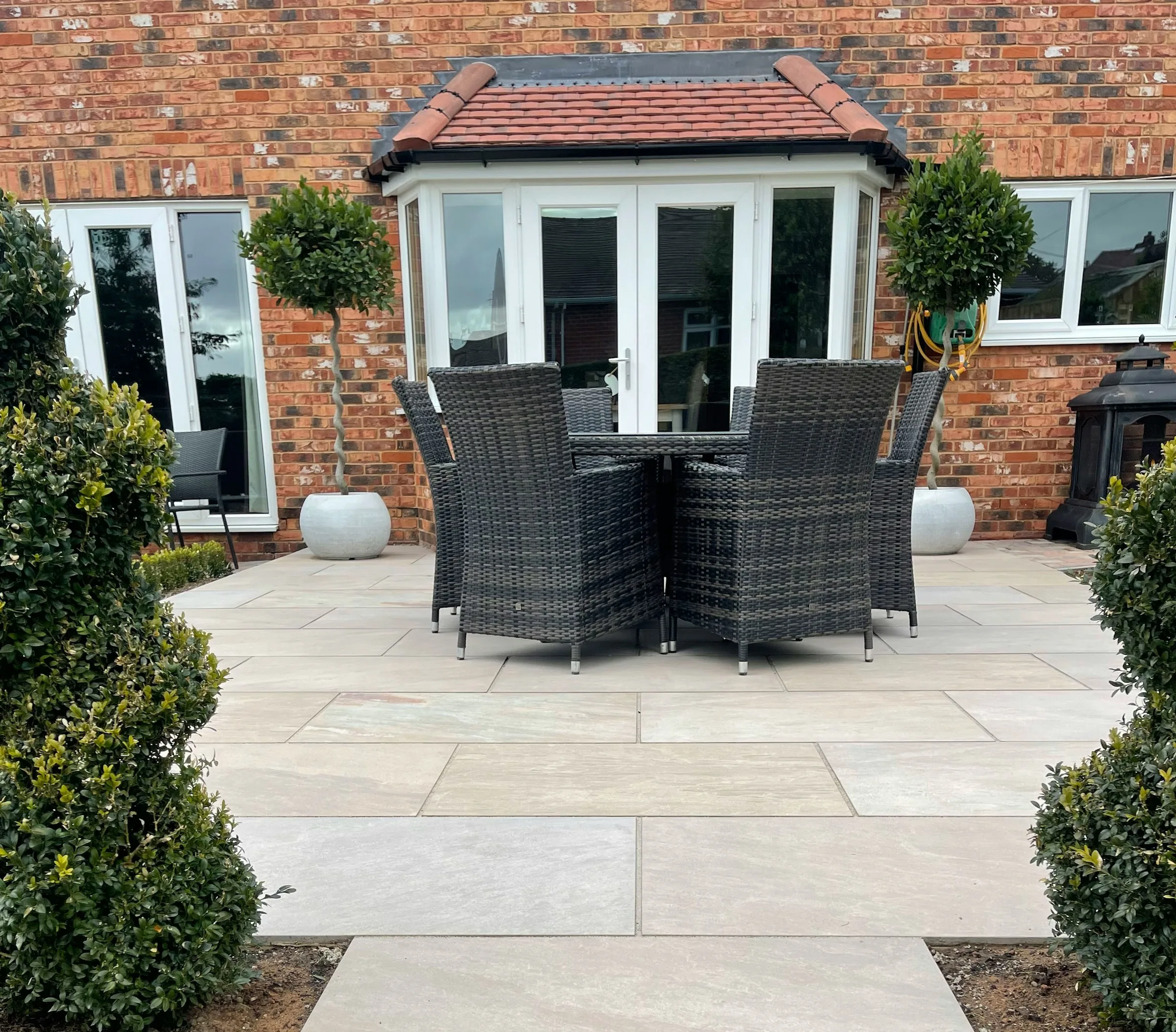 Brick home opening onto a furnished garden patio